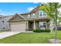 Charming two-story home featuring a well-manicured lawn and attached two-car garage, with a quaint front porch at 1460 Boots Trl, Greenfield, IN 46140