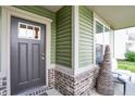 View of front entry porch with brick base, decorative chair and window view at 1460 Boots Trl, Greenfield, IN 46140