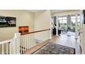Bright hallway with tiled floors, wooden railings, leading into the living area with large windows at 14737 Macduff Dr, Noblesville, IN 46062