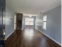 View of the open living room with wood floors, neutral paint, and staircase at 187 Broadmoor Bnd, Pittsboro, IN 46167