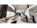 Bright, open living room with high ceilings, large windows, and elegant staircase at 19824 Atwater Ave, Sheridan, IN 46069