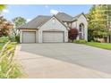 Two story brick home with a three-car garage and long concrete driveway at 2320 Whispering Way, Indianapolis, IN 46239