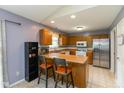 Bright eat-in kitchen with wood cabinets, stainless refrigerator, and breakfast bar seating at 31 Morningside Ct, Whiteland, IN 46184