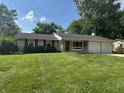 Charming ranch-style home featuring a well-manicured lawn, red shutters, and an attached two-car garage at 4032 Roselawn Ave, Columbus, IN 47203