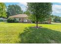 A well-maintained ranch-style home with a spacious front lawn and mature trees at 425 Saddle Hill Ct, Indianapolis, IN 46234