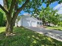 View of a two-story home featuring an attached garage, long driveway, and well-manicured lawn at 4536 Clayburn Dr, Indianapolis, IN 46268