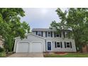 Two-story home with attached garage, featuring a blue door, shutters, and a well-manicured lawn at 4536 Clayburn Dr, Indianapolis, IN 46268
