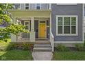 Home's bright yellow front door with white trim and a welcoming front porch at 630 Dorman St, Indianapolis, IN 46202