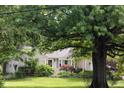 Well-manicured lawn and lush greenery adorn this charming beige home's front exterior at 6379 Monitor Dr, Indianapolis, IN 46220