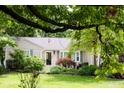 A home with a well-manicured front yard, featuring a variety of plants and green grass at 6379 Monitor Dr, Indianapolis, IN 46220