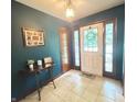 Inviting foyer features tile flooring, decorative lighting, and glass-paneled front door at 6546 Derbyshire Rd, Indianapolis, IN 46227