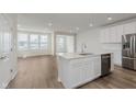 Bright open concept kitchen featuring stainless appliances, modern island and wood flooring at 7282 Shroyer Way, Noblesville, IN 46062