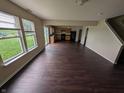 Large, open-concept area with hardwood floors, plenty of natural light, and a view into the kitchen at 908 Belvedere Dr, Shelbyville, IN 46176