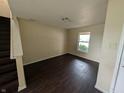 An empty living room with dark wood floors and natural light from one window at 908 Belvedere Dr, Shelbyville, IN 46176