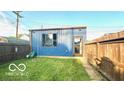 Fenced backyard featuring a modern-style outbuilding with a window and door at 909 Pearl St, Columbus, IN 47201