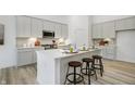 Modern kitchen featuring white cabinetry, stainless steel appliances, a center island and breakfast bar at 10319 Little Island Dr, Indianapolis, IN 46239