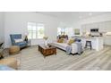 Open-concept living room with bright, neutral decor, large windows, and seamless flow to the kitchen at 10319 Little Island Dr, Indianapolis, IN 46239