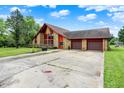 Charming home featuring stone accents, a two-car garage, and long driveway at 13151 W Youth Camp Rd, Columbus, IN 47201