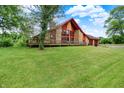Charming home featuring stone accents, a large deck, and a spacious front yard at 13151 W Youth Camp Rd, Columbus, IN 47201