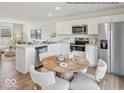 Modern kitchen featuring stainless steel appliances, white cabinets, a large island, and round table in an inviting eat-in space at 1334 Aster Dr, Shelbyville, IN 46176