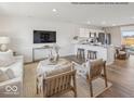 Open-concept living space with modern furnishings, hardwood floors, connecting the living room, kitchen, and dining areas at 1334 Aster Dr, Shelbyville, IN 46176