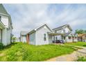 Cozy single-Gathering home with a quaint covered porch perfect for enjoying the outdoors and grassy front lawn at 2111 Central Ave, Anderson, IN 46016