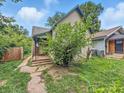 View of the house, greenery, with a walkway leading to the front entrance and overgrown yard at 2426 Lasalle St, Indianapolis, IN 46218