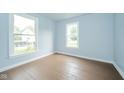 Bright bedroom featuring hardwood floors and natural light from two windows at 2627 Chase St, Anderson, IN 46016