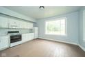 Bright kitchen featuring white appliances, cabinetry, and natural light at 2627 Chase St, Anderson, IN 46016