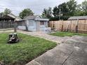 View of the backyard with a small outbuilding and a combination of concrete and grass landscaping at 2731 Delaware St, Anderson, IN 46016
