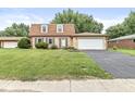 Charming brick home featuring a well-maintained lawn and two-car attached garage at 3224 Prague Rd, Indianapolis, IN 46227