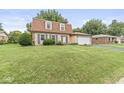 Charming brick home featuring a well-maintained lawn and two-car attached garage at 3224 Prague Rd, Indianapolis, IN 46227