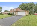 Charming brick home featuring a well-maintained lawn and two-car attached garage at 3224 Prague Rd, Indianapolis, IN 46227