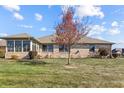 Picture of the backyard with a screened-in porch that is attached to a brick house and a grass filled backyard at 3784 Mansfield Dr, Brownsburg, IN 46112