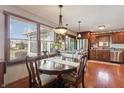 Inviting dining area with hardwood floors, large windows, and stylish chandelier fixture, adjacent to the kitchen at 3784 Mansfield Dr, Brownsburg, IN 46112