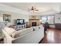 Comfortable living room featuring a brick fireplace, hardwood floors, ceiling fan, and a vaulted ceiling at 3784 Mansfield Dr, Brownsburg, IN 46112