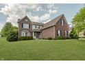 Beautiful brick two-story home with manicured lawn, mature trees, and classic architectural details at 4150 Huntsman Dr, Zionsville, IN 46077