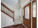 Welcoming foyer with hardwood floors, a staircase with wooden banister, and a decorative front door at 4150 Huntsman Dr, Zionsville, IN 46077