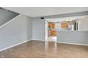 Open concept living room with hardwood floors seamlessly connects to the kitchen and dining area at 5541 Lippan Way, Indianapolis, IN 46221