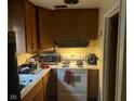 View of a compact kitchen with dated appliances and wooden cabinets at 8256 Meadowlark Dr, Indianapolis, IN 46226
