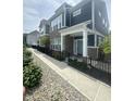 Charming two-story townhome with brick and vinyl siding, black iron fence, sidewalk and landscaped front yard at 9215 Hawley Dr, Indianapolis, IN 46216