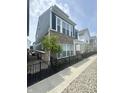 Charming two-story townhome with brick and vinyl siding, black iron fence, sidewalk and landscaped front yard at 9215 Hawley Dr, Indianapolis, IN 46216