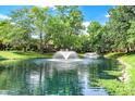 Picturesque pond view with fountains surrounded by mature trees on a sunny day at 9578 Cadbury Cir, Indianapolis, IN 46260