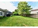 Spacious backyard with lush lawn, patio area, and mature trees, ideal for outdoor gatherings at 10173 Stillwell Dr, Avon, IN 46123