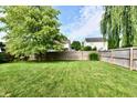 Expansive backyard featuring green grass, a wooden fence, and mature trees offering shade at 10173 Stillwell Dr, Avon, IN 46123