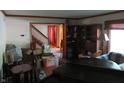 View of living room that features a staircase, wood trim, piano, and hardwood floors at 1327 Goldfinch Dr, Carmel, IN 46032