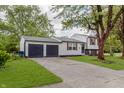 View of the home and attached two-car garage, showcasing the lawn and driveway at 1537 Mutz Dr, Indianapolis, IN 46229