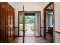 Inviting foyer featuring a half glass front door, wood floors and trim, and coat closet at 180 Wellington Pkwy, Noblesville, IN 46060