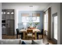 Well-lit dining room with modern light fixture and an open view to the kitchen at 19796 Chatham Shore Ln, Westfield, IN 46074