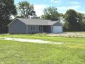 A charming gray house with an attached two-car garage, set in a lush green yard with mature trees at 2071 S Friendship Dr, Paragon, IN 46166